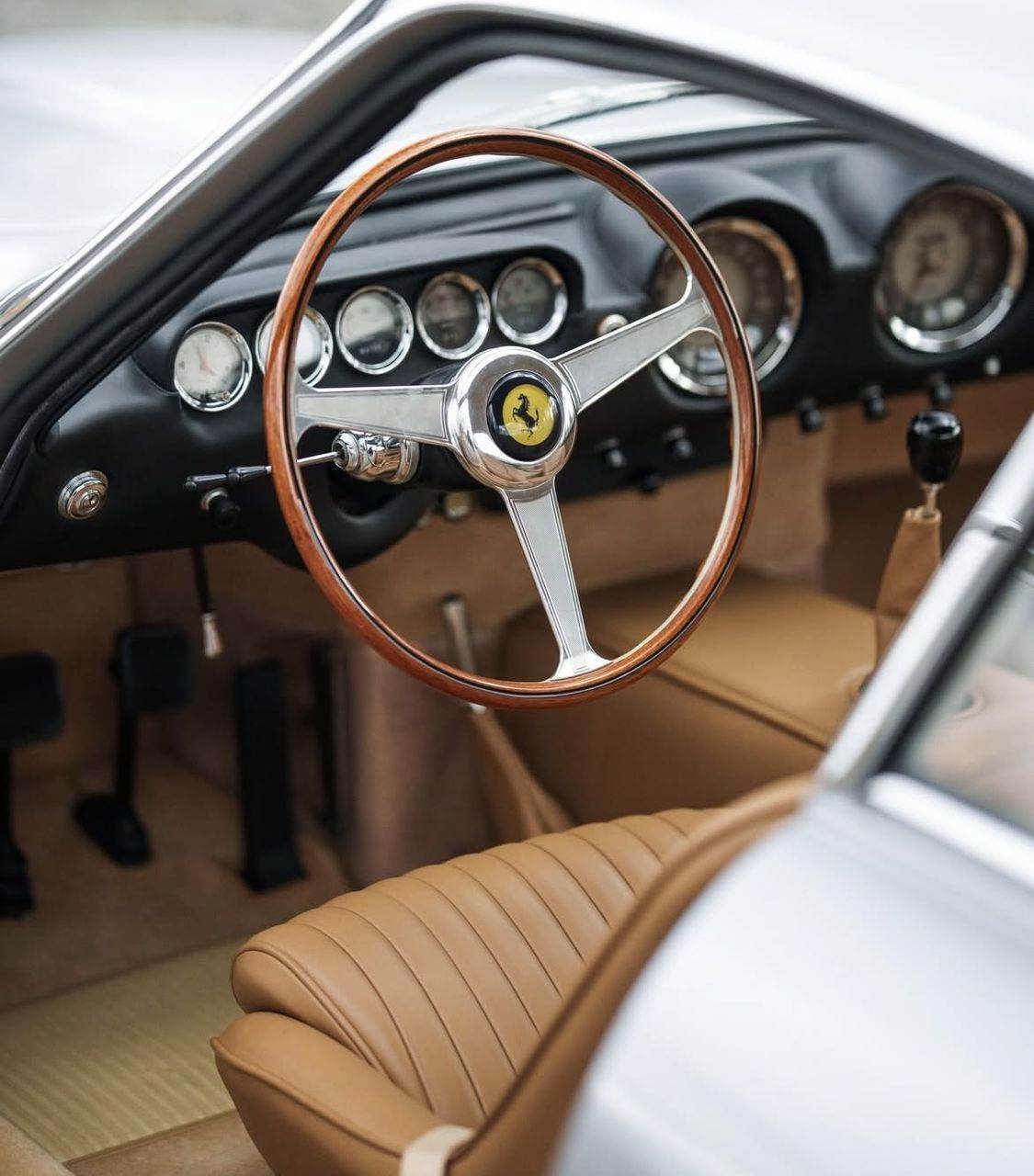 Classic Ferrari interior with a wooden steering wheel, kept in indoor storage in Essex