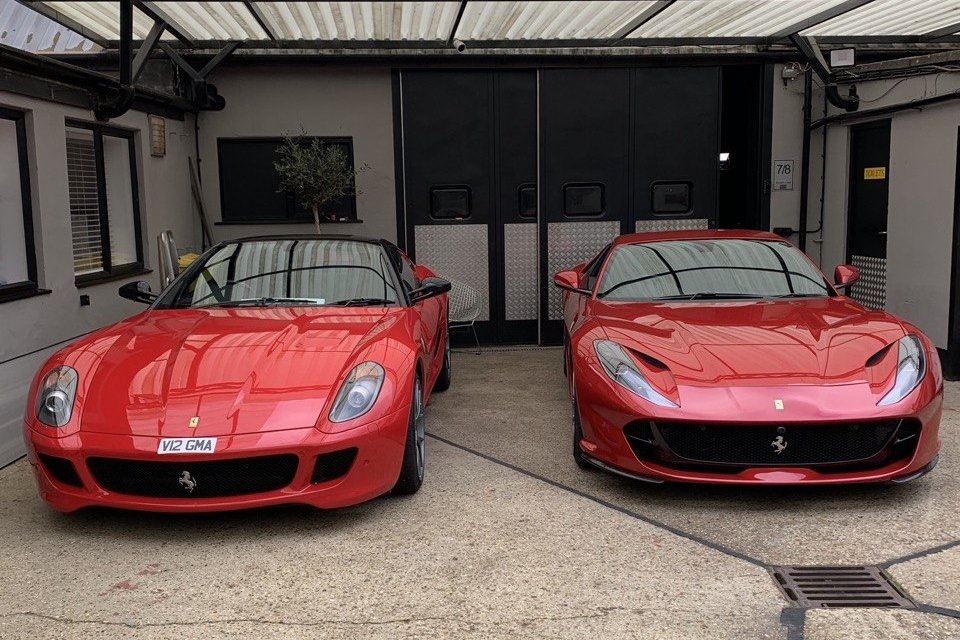 Pair of red Ferraris photographed front on in secure indoor car storage